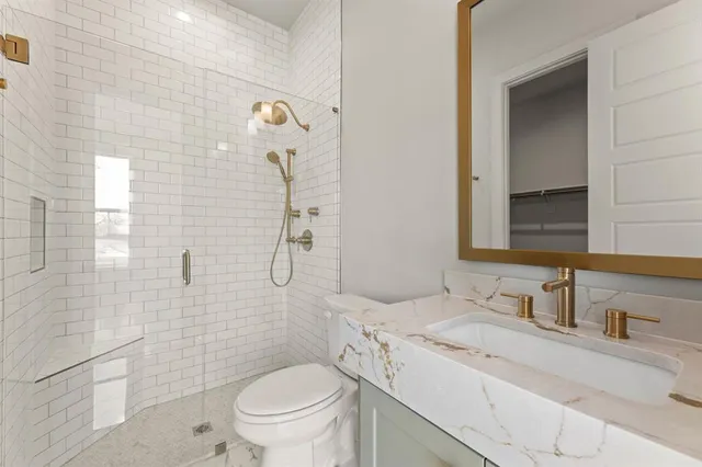 a bathroom with a granite countertop sink toilet and shower