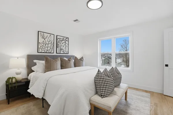 a bedroom with a bed and wooden floor