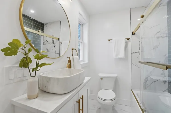 a bathroom with a sink a toilet and a mirror