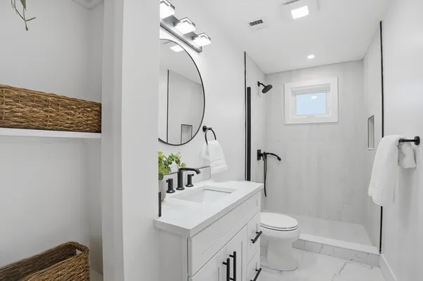 a bathroom with a sink a toilet and shower