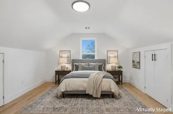 a bedroom with a bed and wooden floor