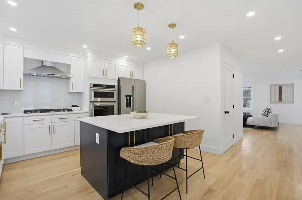 a kitchen with stainless steel appliances kitchen island granite countertop a sink and refrigerator