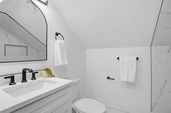 a bathroom with a sink vanity granite and toilet