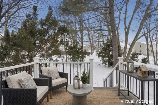 a view of a deck with couches and large trees