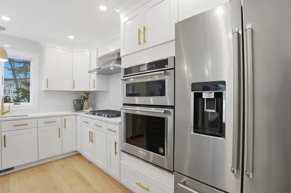 a kitchen with stainless steel appliances a refrigerator sink and stove top oven