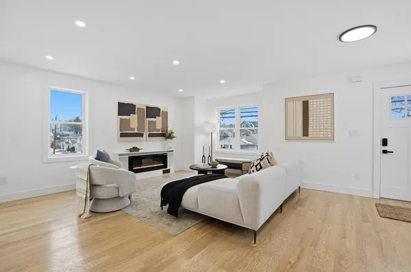 a living room with fireplace furniture and a wooden floor