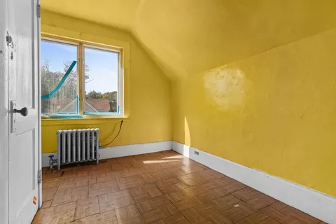 a view of a room with wooden floor and a window