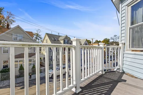 a view of a brick house with wooden fence