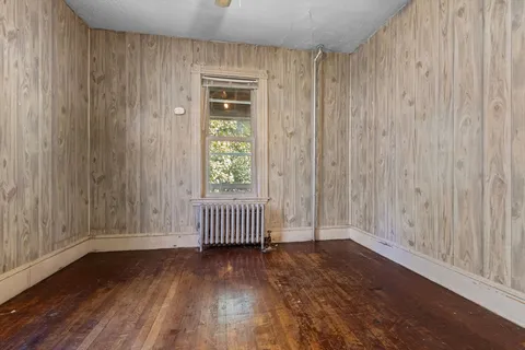a view of a room with wooden floor and windows