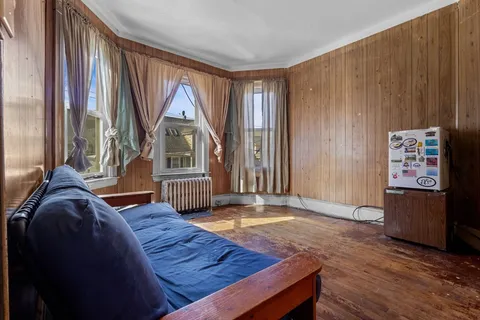 a living room with a bed furniture and a window