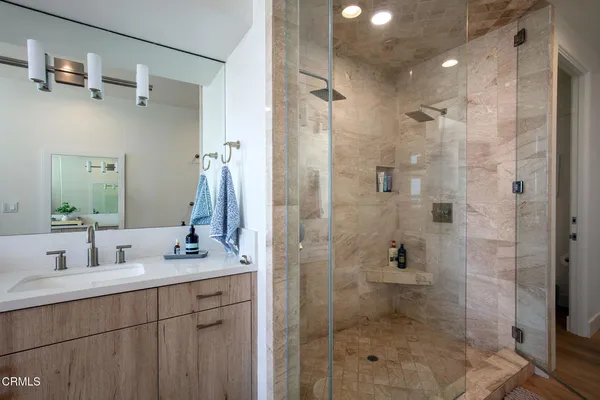 a bathroom with a shower sink and mirror