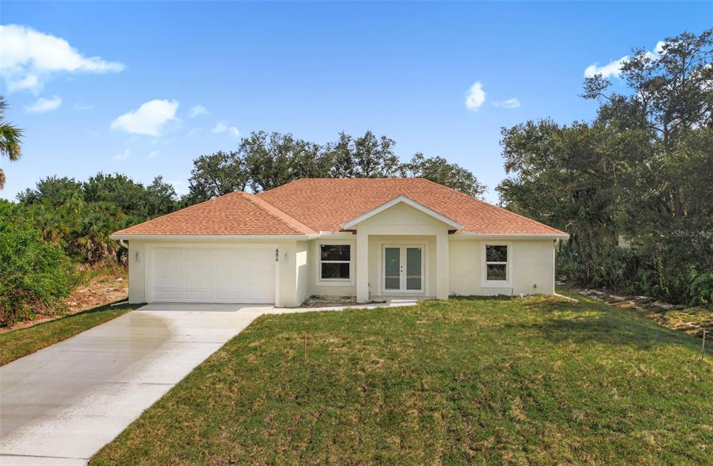 486 Celeste Street Port Charlotte, FL 33954 - Photo 1 of 35 a white house with a big yard plants and large trees