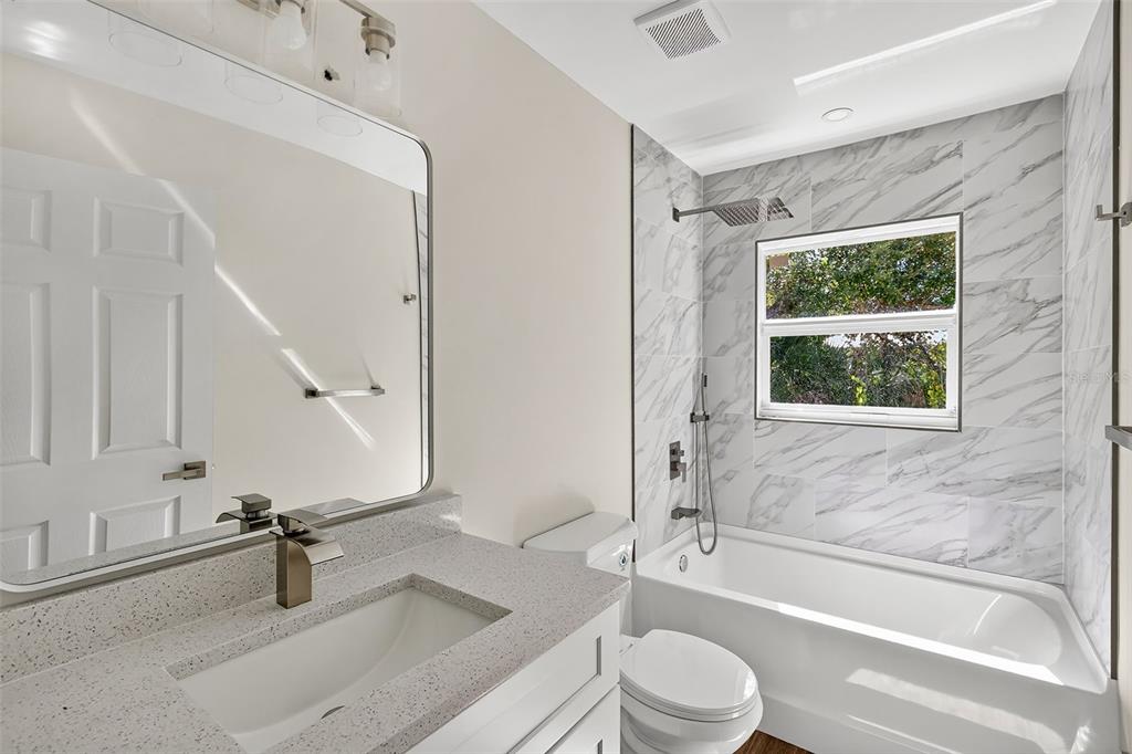 486 Celeste Street Port Charlotte, FL 33954 - Photo 21 of 35 a bathroom with a granite countertop bathtub sink vanity mirror and toilet