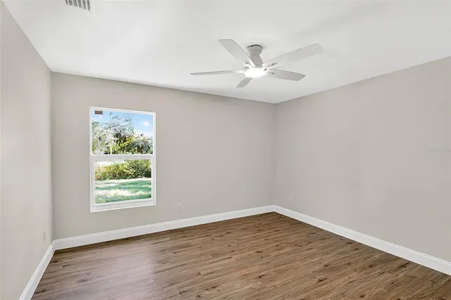 a view of an empty room with wooden floor
