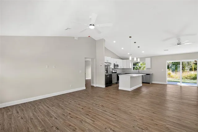 a view of kitchen with kitchen island microwave and stove with wooden floor