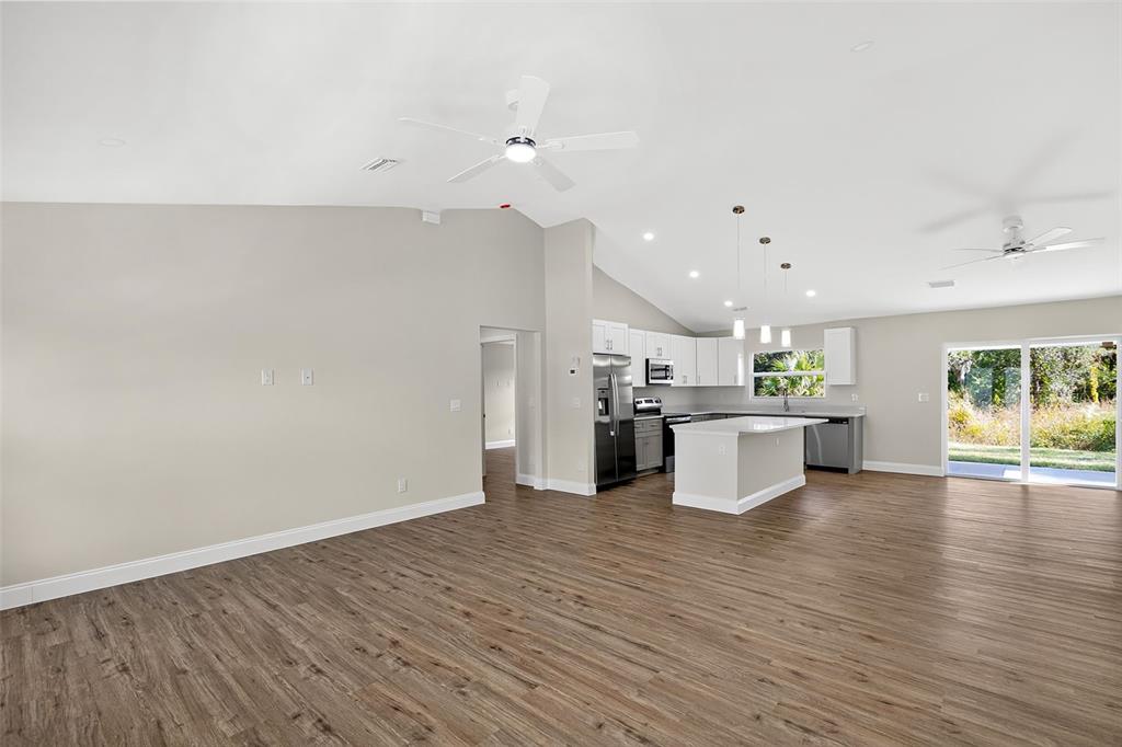 486 Celeste Street Port Charlotte, FL 33954 - Photo 6 of 35 a view of kitchen with kitchen island microwave and stove with wooden floor