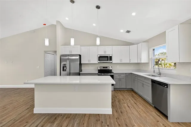 a large kitchen with stainless steel appliances lots of counter top space and cabinets