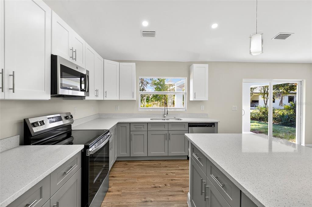 486 Celeste Street Port Charlotte, FL 33954 - Photo 9 of 35 a kitchen with stainless steel appliances granite countertop a sink stove and cabinets