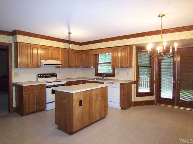 2216 Effingham Circle Raleigh, NC 27615 - Photo 4 of 12 The spacious eat-in Kitchen features lots of wood cabs, island, Pantry, elect range w/self clean oven, dishwasher, disposal, range hood and lg bay-windowed B'fast area w/French drs to the huge Deck.