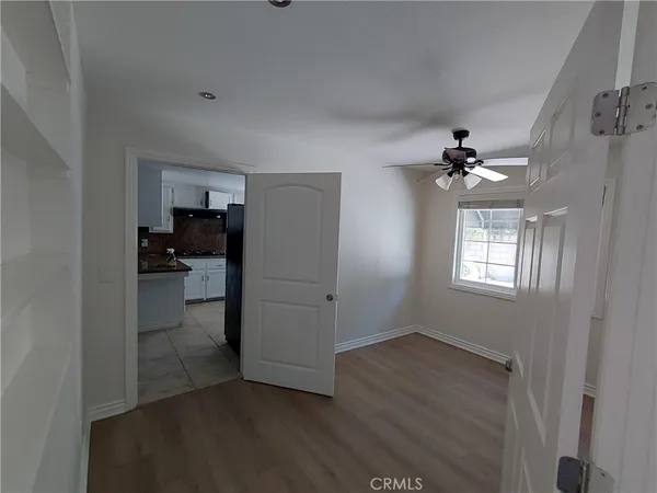 wooden floor in an empty room with a kitchen