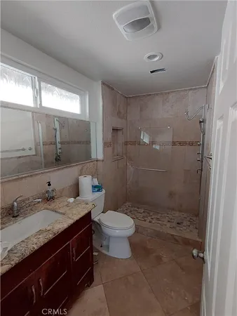 a bathroom with a granite countertop sink toilet and shower