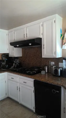 a kitchen with granite countertop white cabinets and a stove