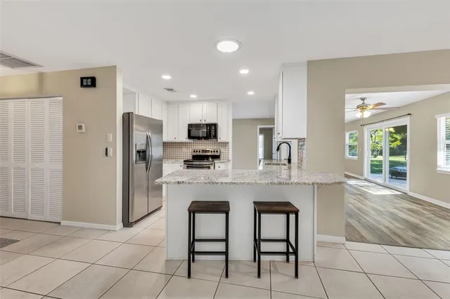 a kitchen with a sink a refrigerator and cabinets