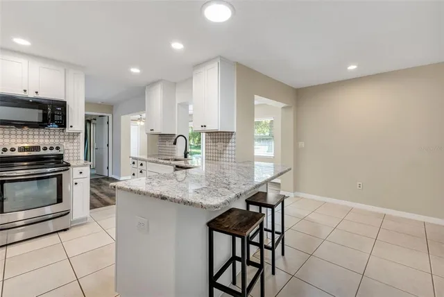 a kitchen with granite countertop white cabinets and a sink