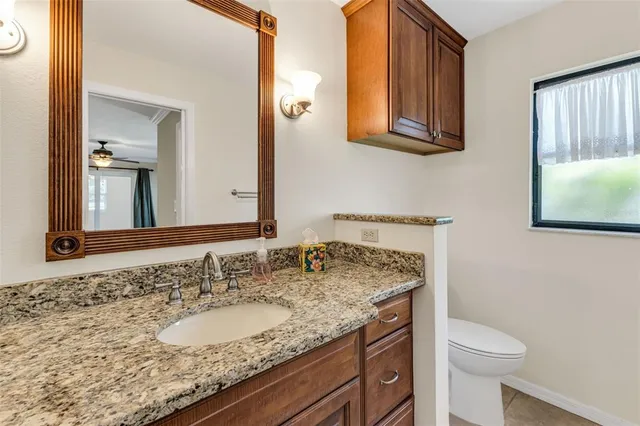 an empty room with chandelier fan and windows