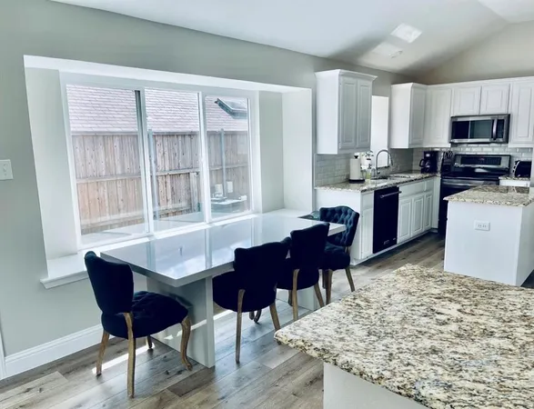 a living room with stainless steel appliances kitchen island granite countertop furniture and a wooden floor
