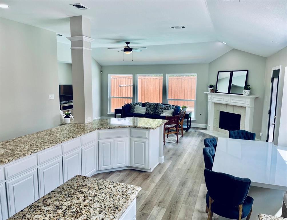 7848 Lancelot Road Frisco, TX 75035 - Photo 17 of 27 a open kitchen with granite countertop a stove a sink dishwasher and a fireplace with wooden floor