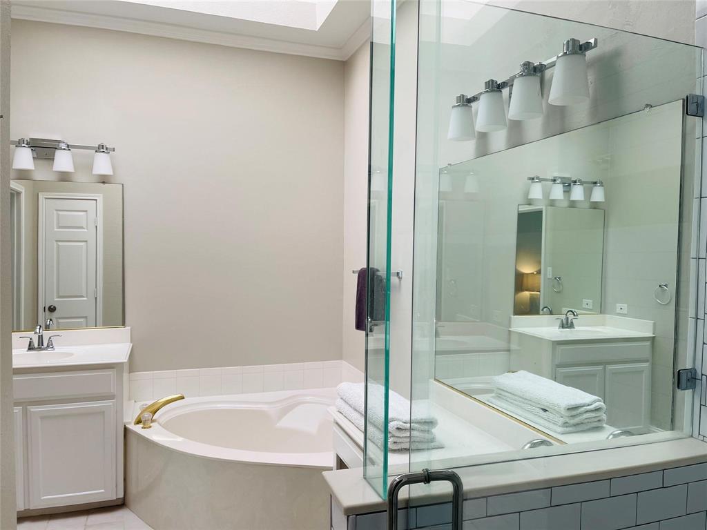 7848 Lancelot Road Frisco, TX 75035 - Photo 19 of 27 a bathroom with a tub a sink and a large mirror