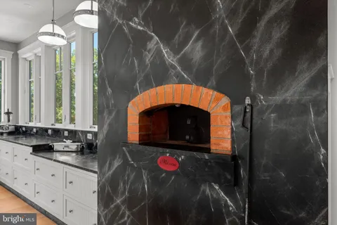 a large kitchen with lots of counter space large windows and a chandelier