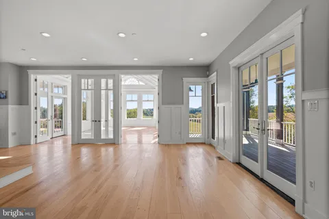 a view of empty room with wooden floor and floor to ceiling window