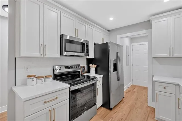 a kitchen with stainless steel appliances a stove microwave and refrigerator