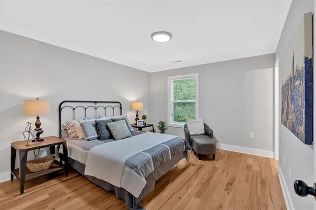 a bedroom with a bed and wooden floor