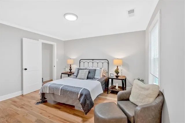a bedroom with a bed and wooden floor