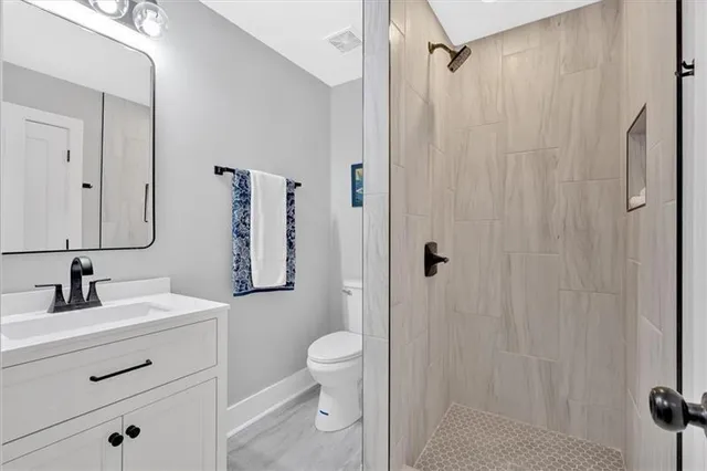 a bathroom with a sink toilet a mirror a vanity and shower