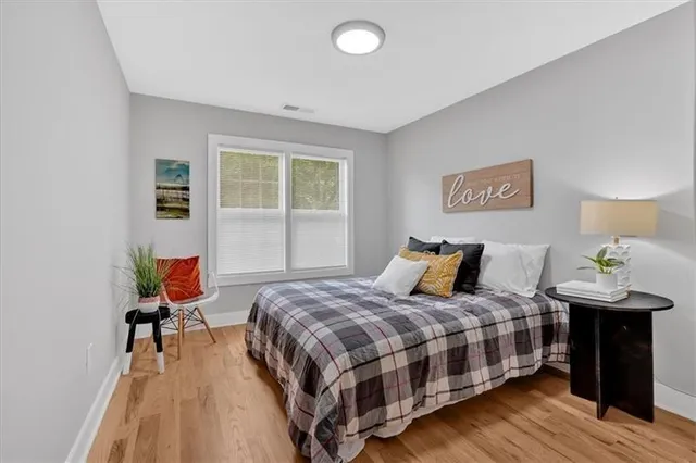 a bedroom with a bed and wooden floor