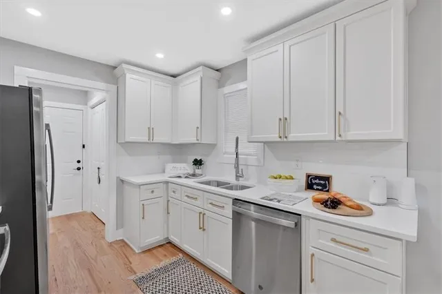 a kitchen with white cabinets and white appliances