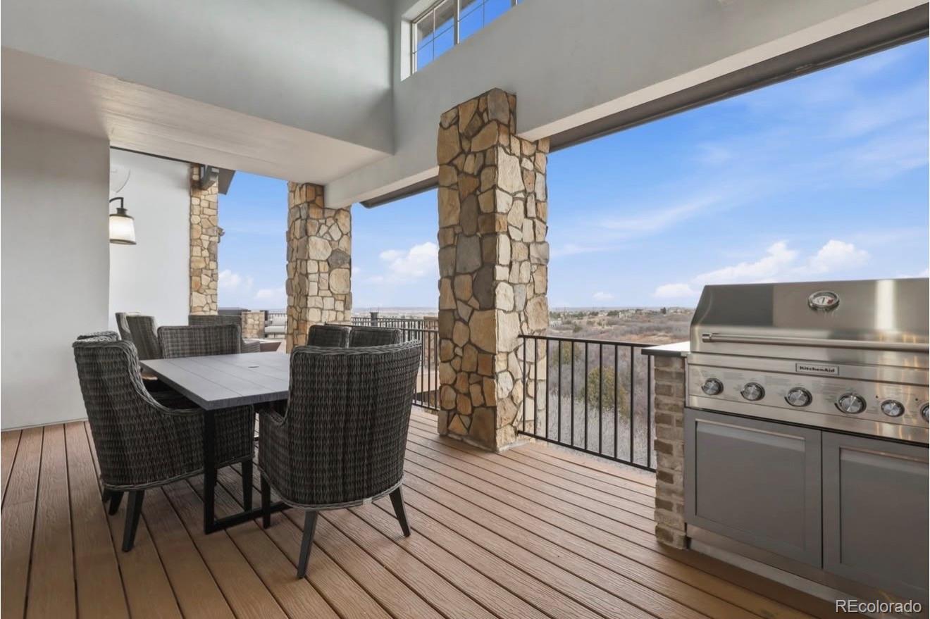 843 Diamond Ridge Circle Castle Rock, CO 80108 - Photo 14 of 31 a view of a roof deck with table and chairs with wooden floor and fence