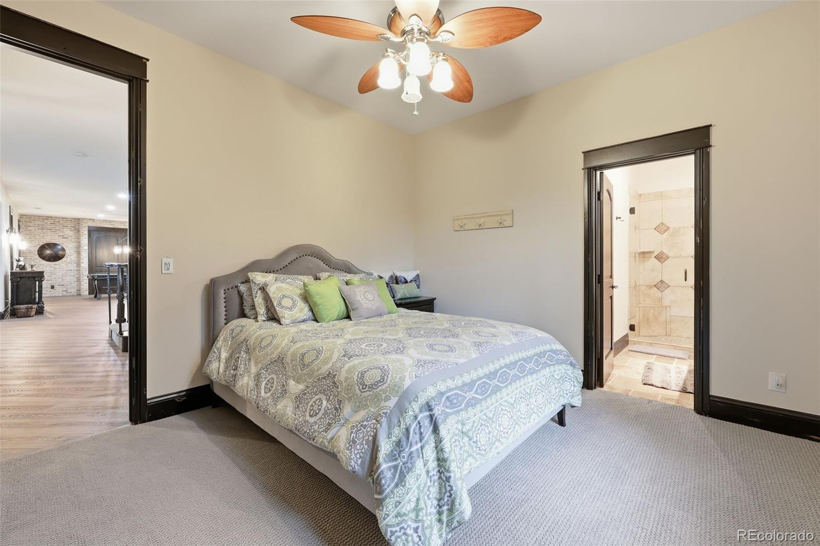 843 Diamond Ridge Circle Castle Rock, CO 80108 - Photo 30 of 31 a spacious bedroom with a bed and a chandelier