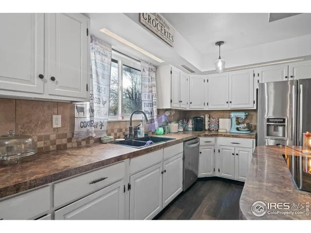 a kitchen with granite countertop a sink stainless steel appliances and cabinets