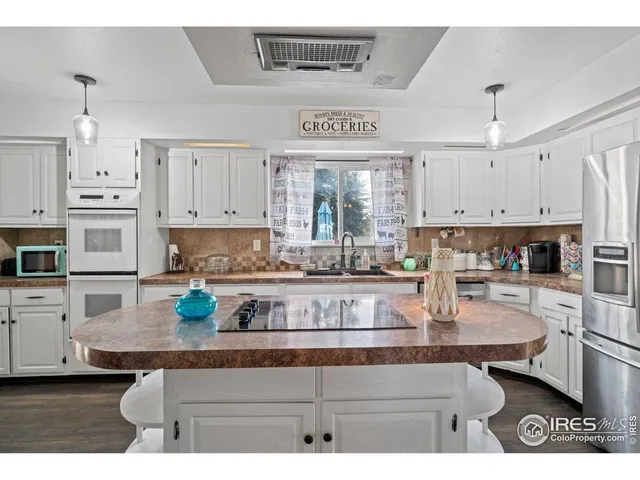 a kitchen with stainless steel appliances granite countertop a stove refrigerator and cabinets