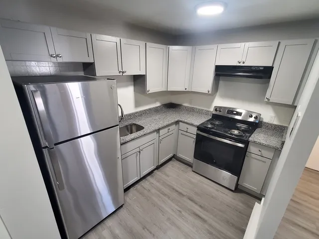 a kitchen with white cabinets and white appliances