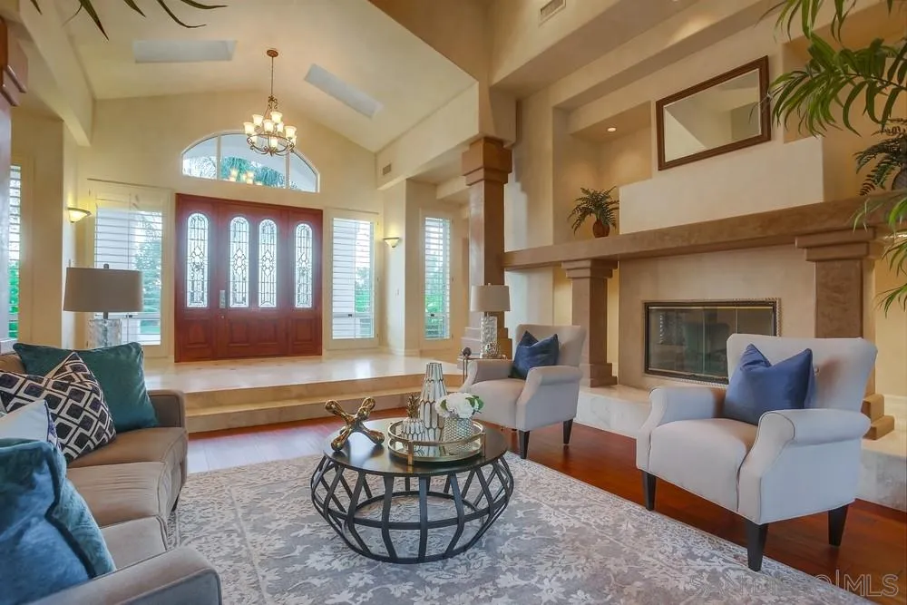 13409 Highlands Ranch Road Poway, CA 92064 - Photo 8 of 24 a living room with furniture a fireplace and a chandelier