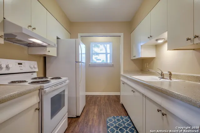 a kitchen with a sink stove and cabinets
