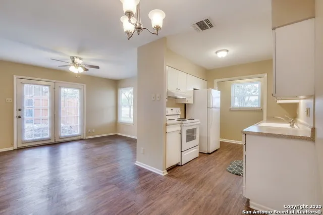 a view of a kitchen with a stove cabinets wooden floor and a ceiling fan