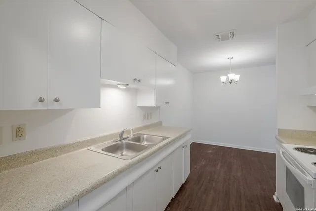 a kitchen that has a sink a stove and cabinets