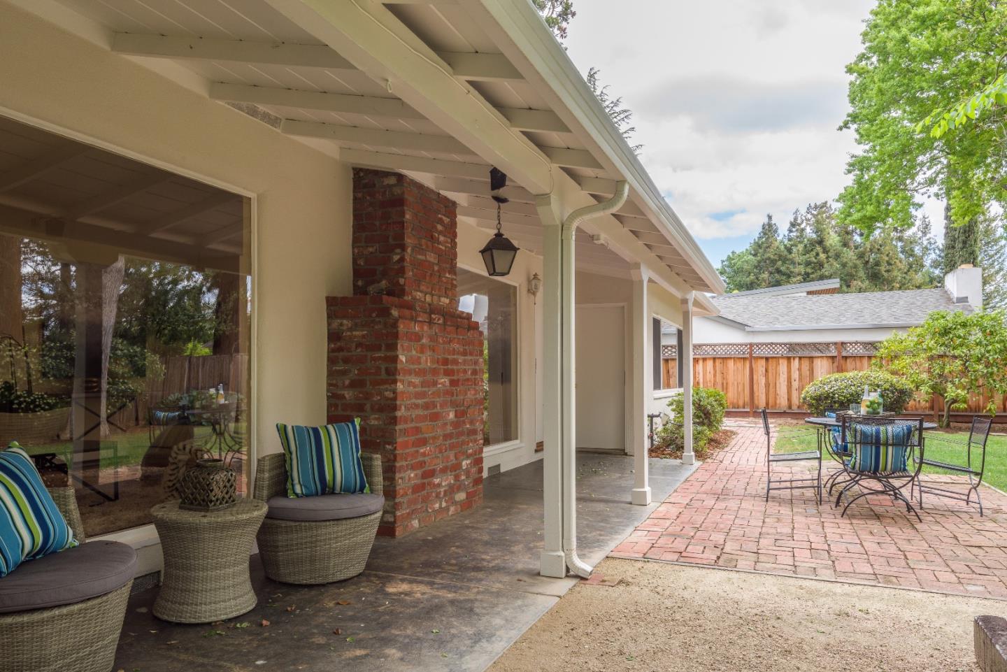 736 Filip Road Los Altos, CA 94024 - Photo 19 of 27 a view of a patio with table and chairs potted plants and floor to ceiling window